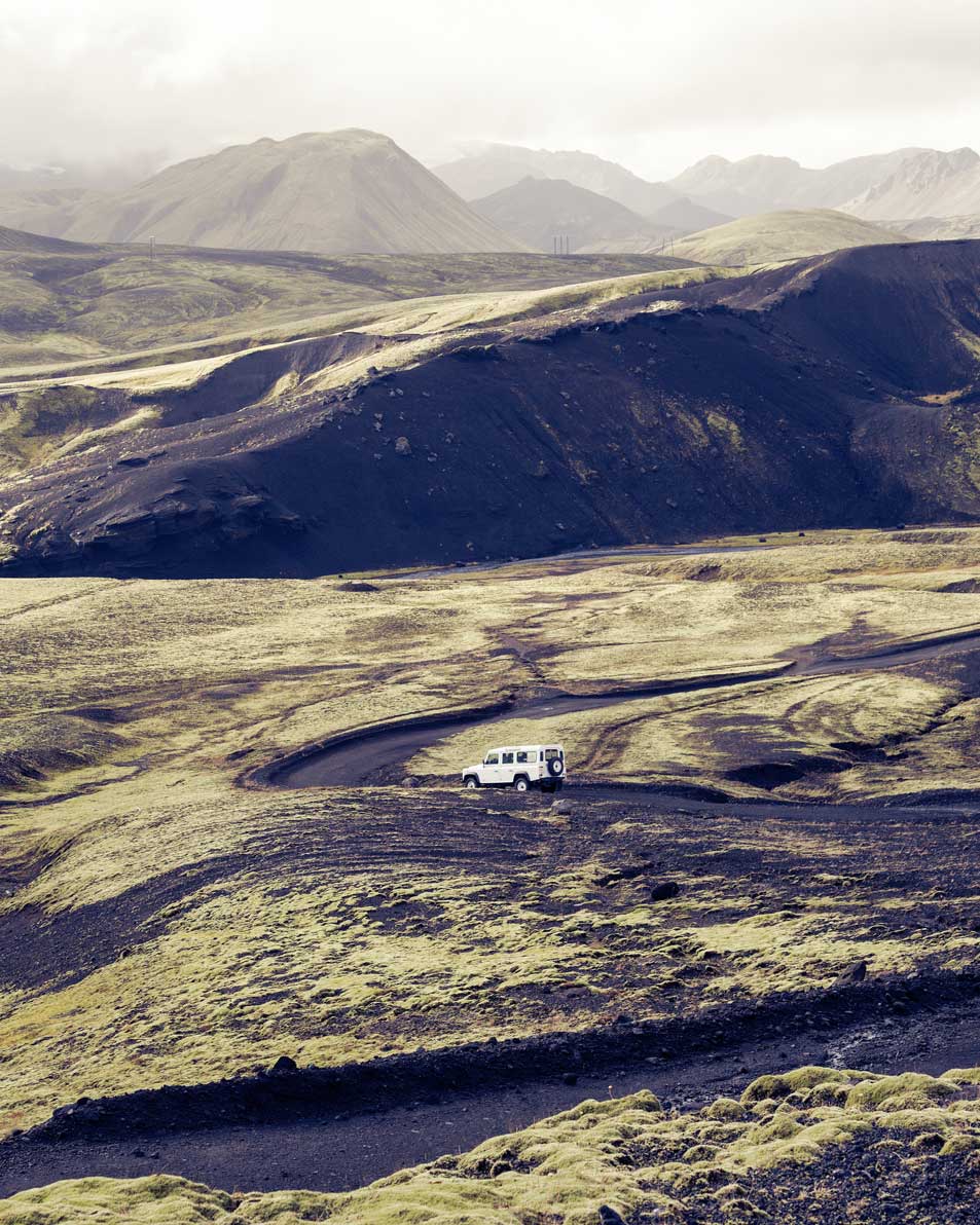 Defender sur une piste dans un vaste paysage volcanique